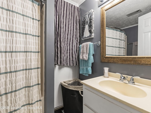 full bath featuring visible vents, a shower with curtain, ornamental molding, a textured ceiling, and vanity