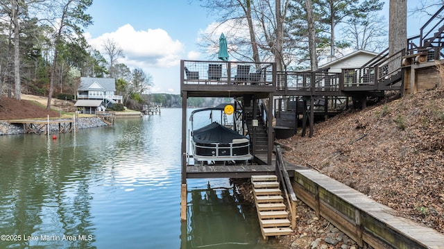 dock area with a water view, boat lift, and stairs