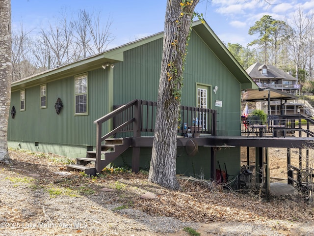 rear view of property featuring crawl space and a deck