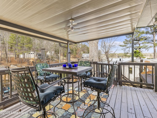 deck featuring outdoor dining area and ceiling fan