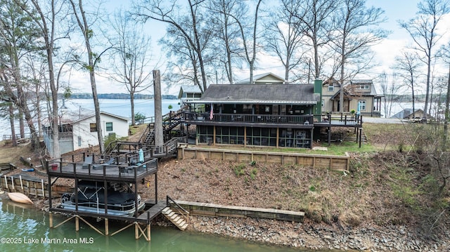 back of property with stairs and a deck with water view