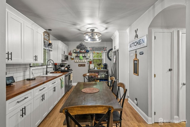 31 Pulawski Ave, South River, NJ 08882 - kitchen featuring wooden counters, a sink, stainless steel appliances, arched walkways, and tasteful backsplash