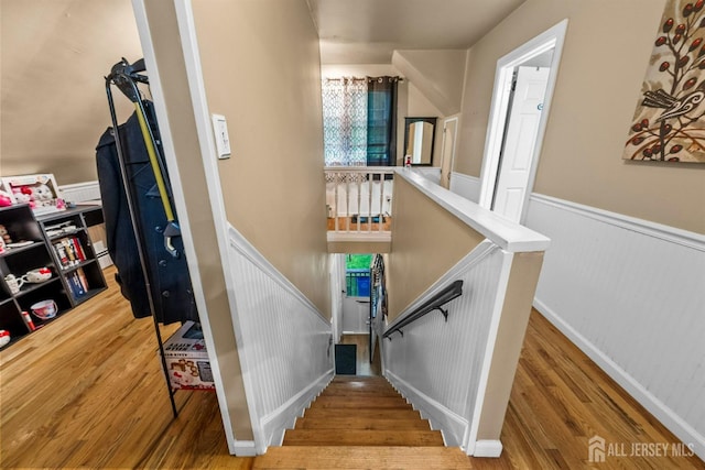 stairway featuring wainscoting and wood finished floors