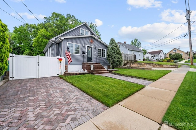 bungalow-style home featuring a gate, decorative driveway, and a residential view