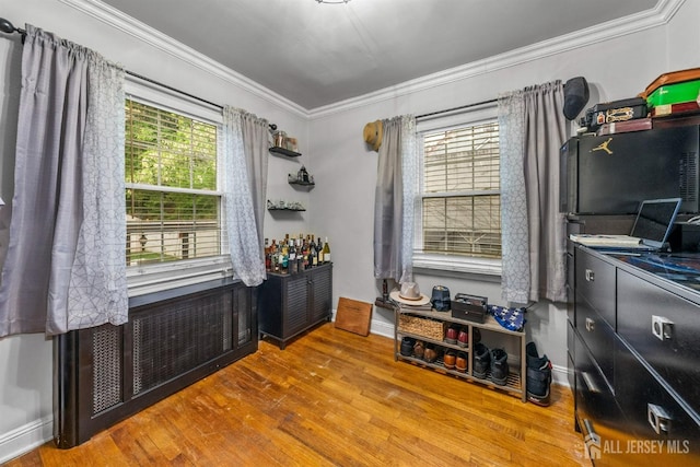 dining area featuring wood finished floors and crown molding