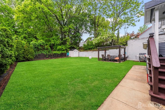 view of yard featuring a shed, a patio area, an outdoor structure, and outdoor dining space