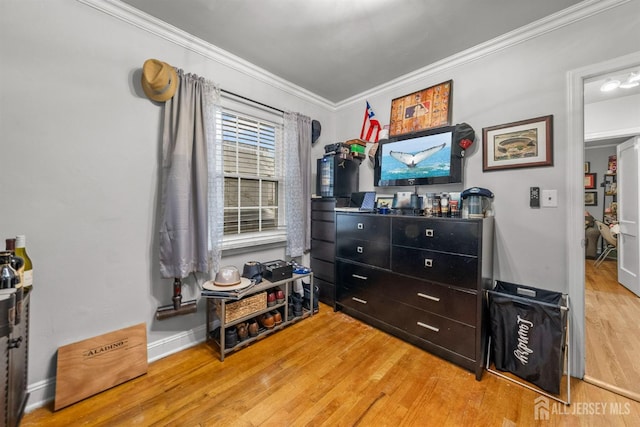 bedroom featuring ornamental molding, wood finished floors, and baseboards