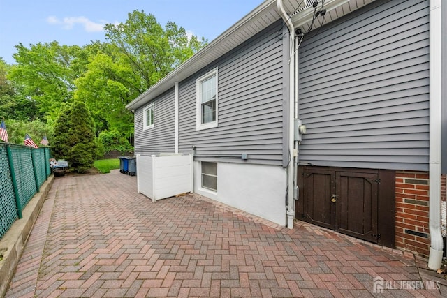 view of home's exterior with fence and a patio area