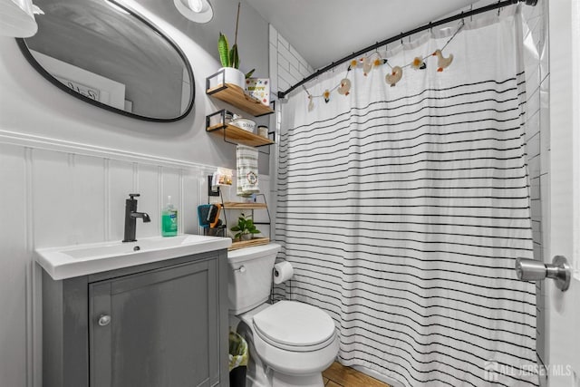 bathroom featuring toilet, vanity, and curtained shower