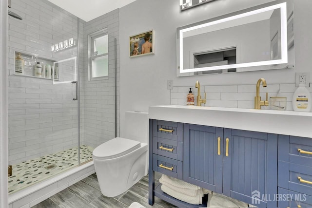 bathroom featuring vanity, an enclosed shower, and toilet