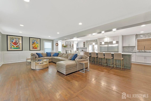 living room featuring sink and light wood-type flooring