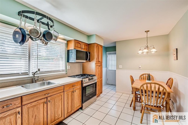 20 Melville Rd, Edison, NJ 08817 - kitchen with stainless steel appliances, wainscoting, hanging light fixtures, light countertops, and a chandelier