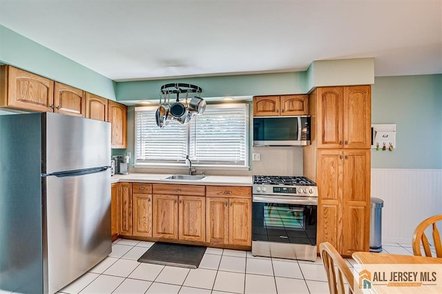 20 Melville Rd, Edison, NJ 08817 - kitchen with appliances with stainless steel finishes, light countertops, a wainscoted wall, brown cabinets, and a chandelier
