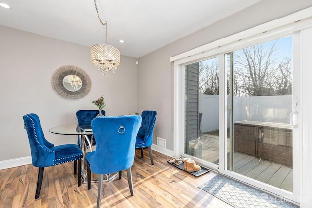 dining area featuring hardwood / wood-style flooring and a notable chandelier