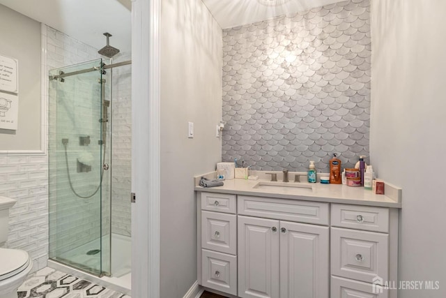 bathroom featuring toilet, a shower stall, and vanity