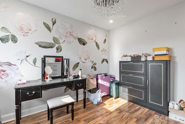 office space with an inviting chandelier, baseboards, and wood finished floors