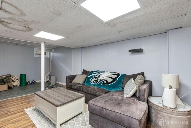 living room with hardwood / wood-style floors and a drop ceiling