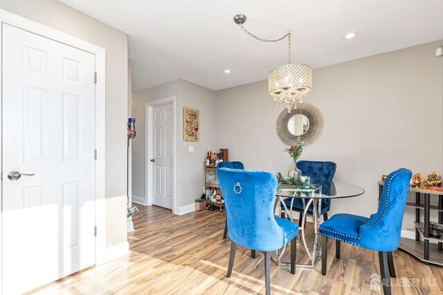 dining space with a chandelier, recessed lighting, wood finished floors, and baseboards