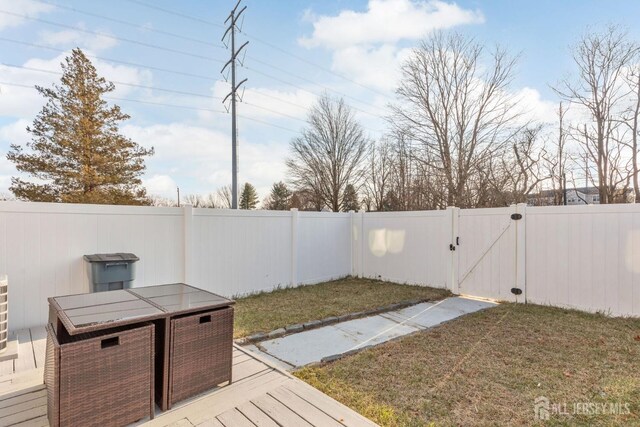 view of yard with a fenced backyard and a gate