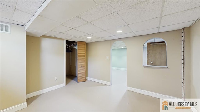 below grade area with a paneled ceiling, visible vents, baseboards, and recessed lighting