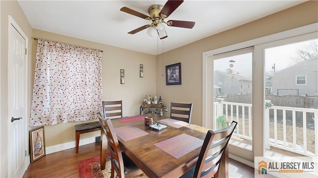 dining space with baseboards, a ceiling fan, and wood finished floors