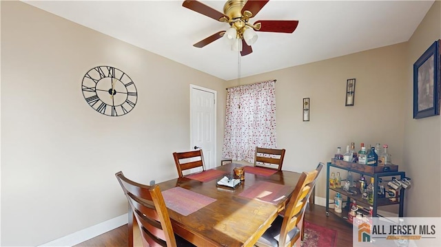 dining space with dark wood-type flooring, a ceiling fan, and baseboards