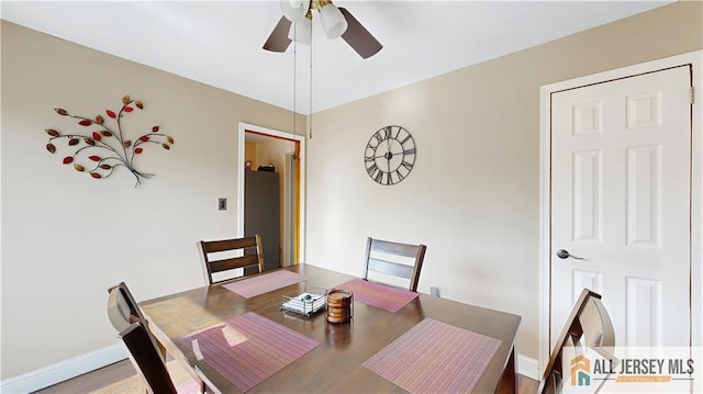 dining space featuring ceiling fan, wood finished floors, and baseboards