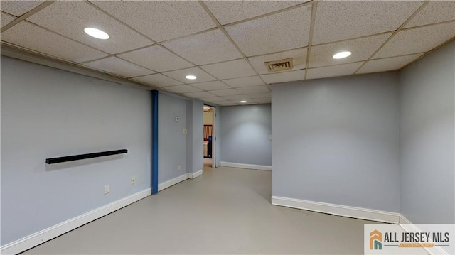 finished below grade area featuring recessed lighting, visible vents, a paneled ceiling, and baseboards