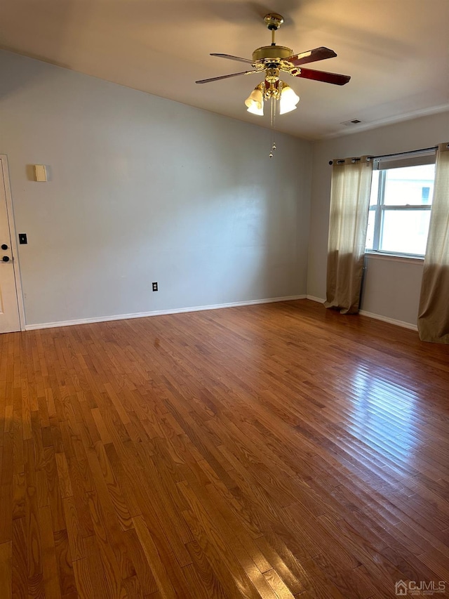 spare room with hardwood / wood-style flooring and ceiling fan