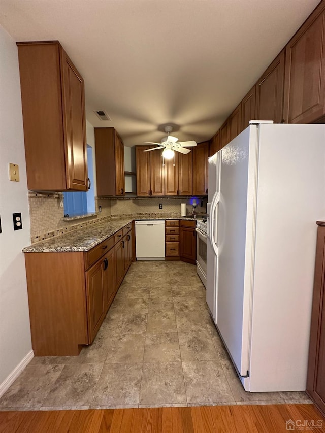 kitchen with light stone counters, white appliances, decorative backsplash, and ceiling fan