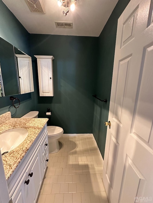 bathroom featuring vanity, toilet, and tile patterned flooring