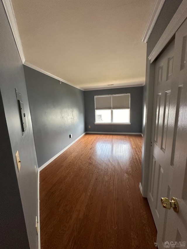 unfurnished room with crown molding and wood-type flooring