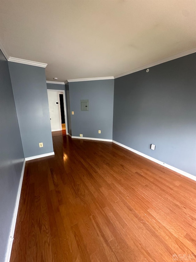 empty room with crown molding and wood-type flooring