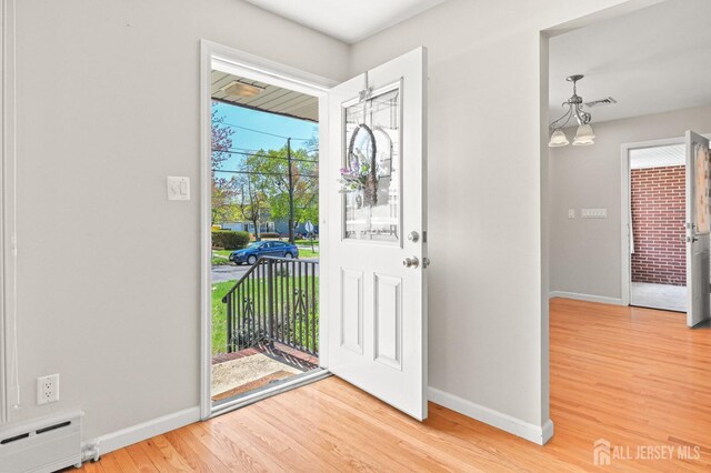 entryway featuring baseboards, wood finished floors, and baseboard heating