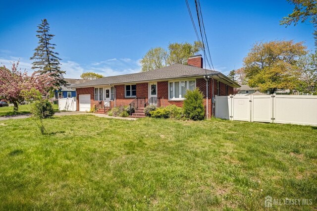 ranch-style home featuring a chimney, a gate, a garage, brick siding, and a front lawn