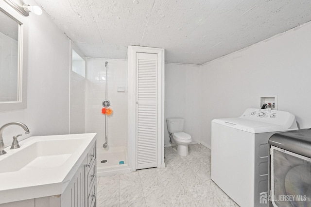bathroom featuring a shower stall, vanity, a closet, toilet, and separate washer and dryer