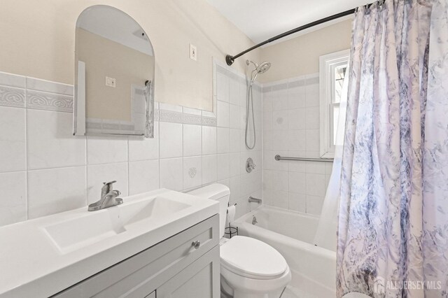 full bath with vanity, shower / bath combination with curtain, toilet, and tile walls