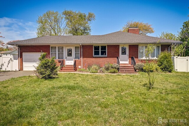 ranch-style house featuring a garage, fence, a front yard, a chimney, and brick siding