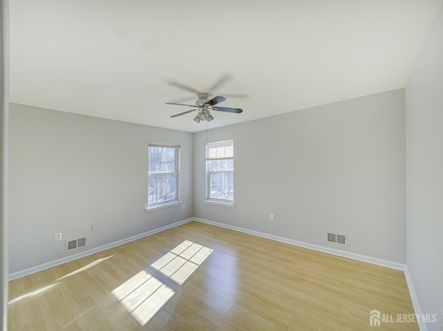 unfurnished room with ceiling fan, baseboards, and light wood finished floors