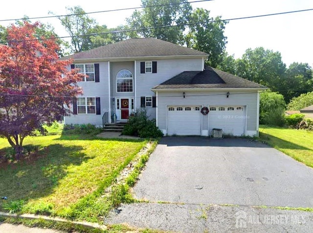 colonial house with driveway, an attached garage, and a front yard