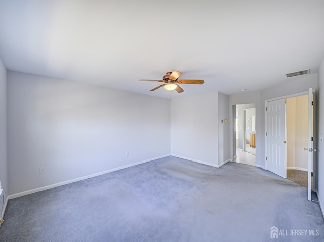carpeted spare room with baseboards and a ceiling fan