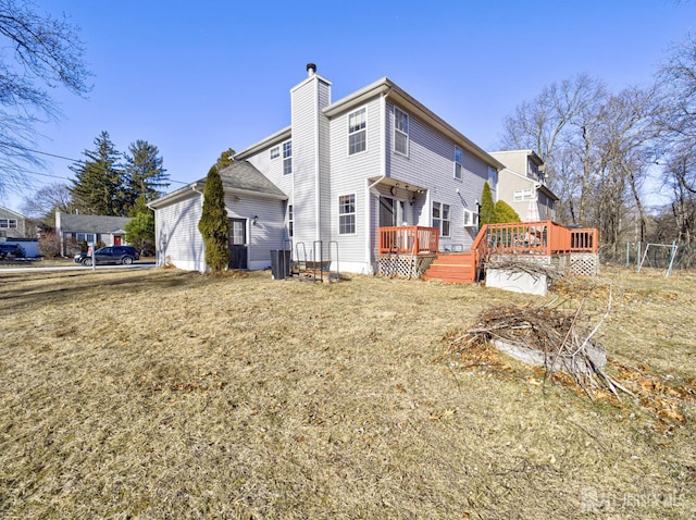 rear view of property with a chimney and a deck