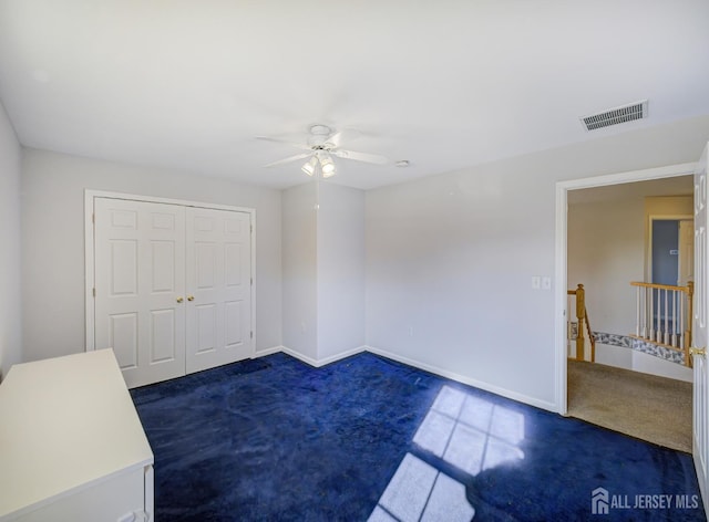 carpeted spare room featuring a ceiling fan and baseboards