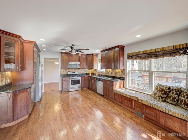kitchen with appliances with stainless steel finishes, decorative backsplash, light wood-style flooring, ceiling fan, and recessed lighting