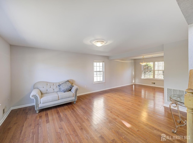unfurnished room featuring plenty of natural light, light wood-style floors, and baseboards