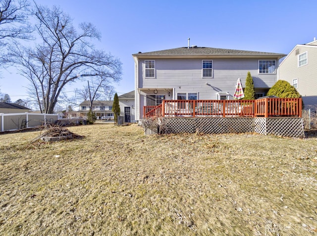 rear view of house with a wooden deck and fence