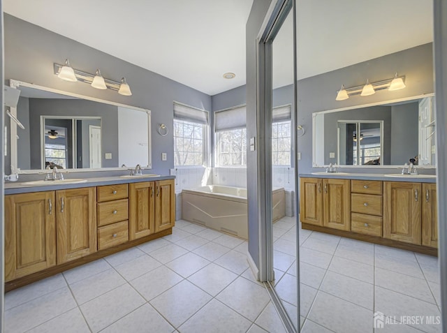 full bath with tile patterned flooring, double vanity, and a bath