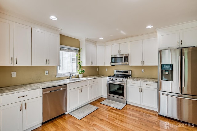 169 Metuchen Ave, Woodbridge Proper, NJ 07095 - kitchen featuring appliances with stainless steel finishes, white cabinetry, light wood finished floors, light stone counters, and recessed lighting
