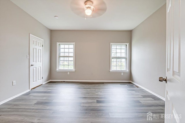 spare room featuring hardwood / wood-style flooring, a healthy amount of sunlight, and ceiling fan