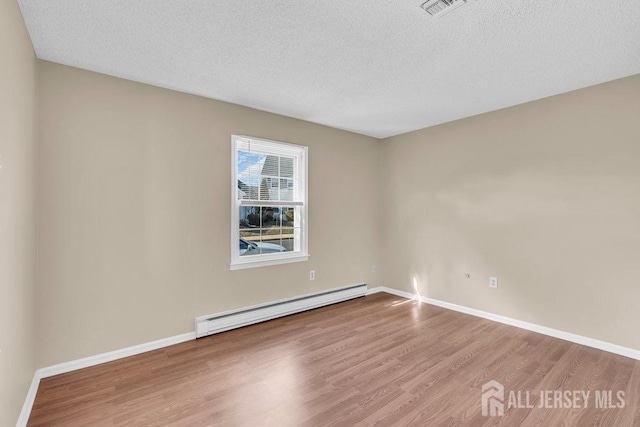 162 Providence Way, Monroe, NJ 08831 - spare room with a baseboard radiator, visible vents, wood finished floors, and a textured ceiling